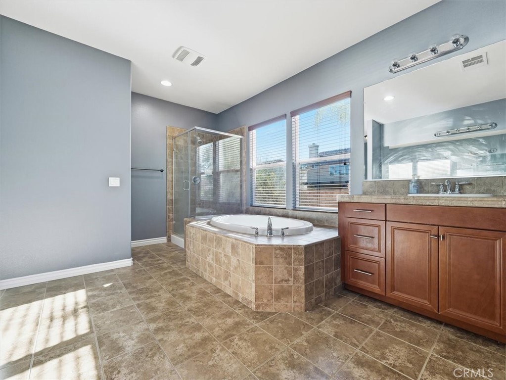2947 Gilbert Avenue Corona, CA 92881 - Photo 35 of 60 a bathroom with a tub a sink and mirror
