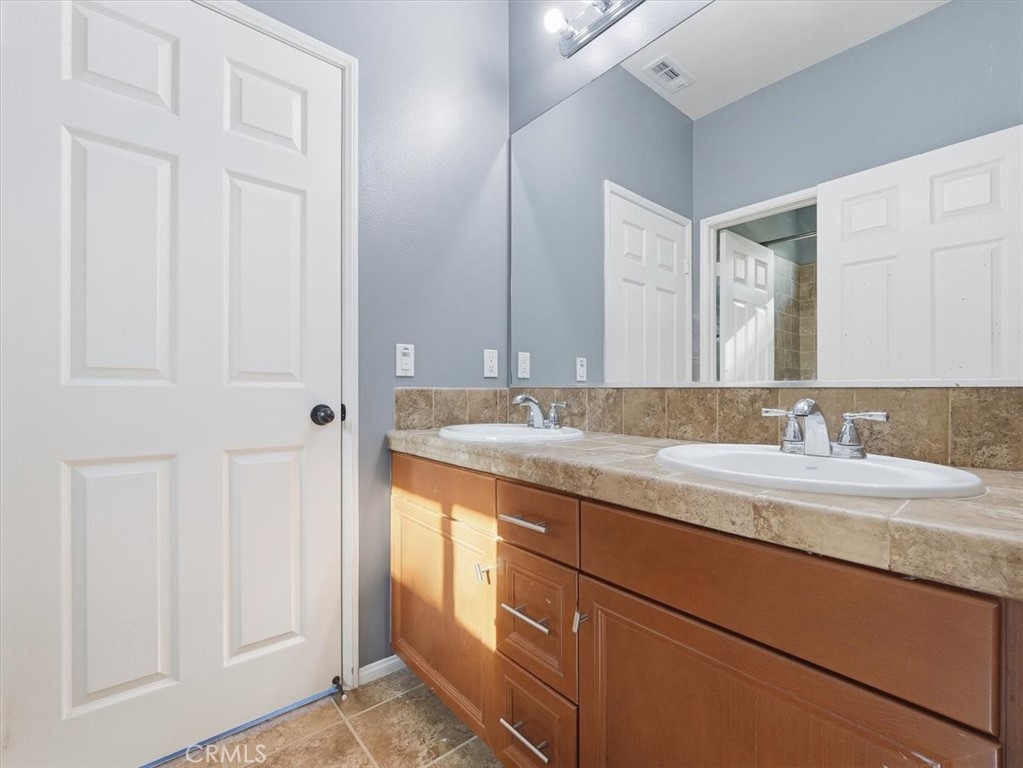 2947 Gilbert Avenue Corona, CA 92881 - Photo 48 of 60 a bathroom with a granite countertop sink and a mirror