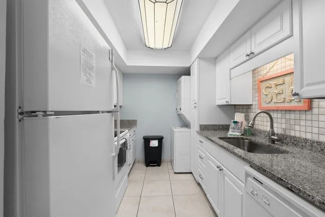 a sink with granite countertop white cabinets and a sink
