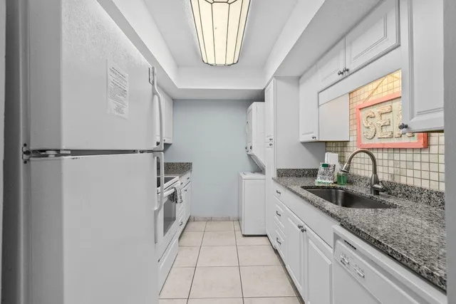 a kitchen with white cabinets and white appliances