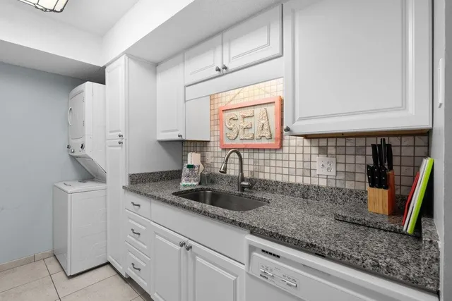 a kitchen with stainless steel appliances granite countertop white cabinets a stove a sink and dishwasher