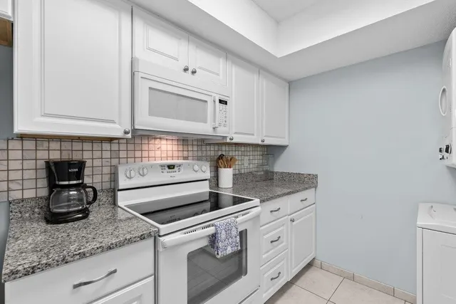 a kitchen with granite countertop a sink stainless steel appliances a counter space and cabinets