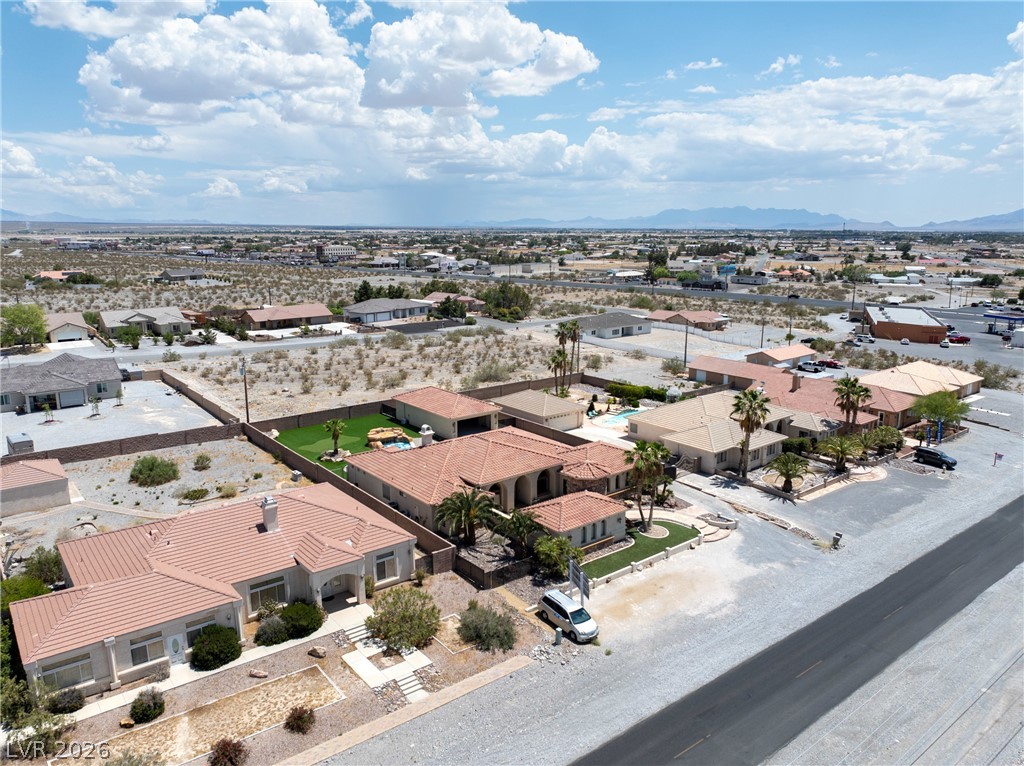 2181 Winery Road Pahrump, NV 89048 - Photo 52 of 52 An aerial panorama reveals a cluster of single-family residences nestled amidst the expansive desert landscape, featuring diverse architectural styles.