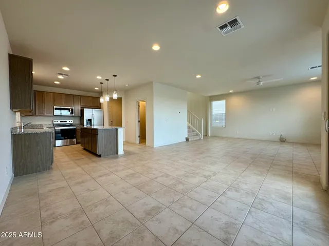 a view of kitchen with stainless steel appliances granite countertop a refrigerator and a stove top oven