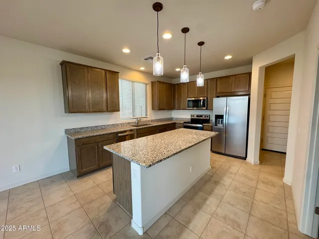 a kitchen with stainless steel appliances granite countertop a sink a stove a refrigerator and a oven