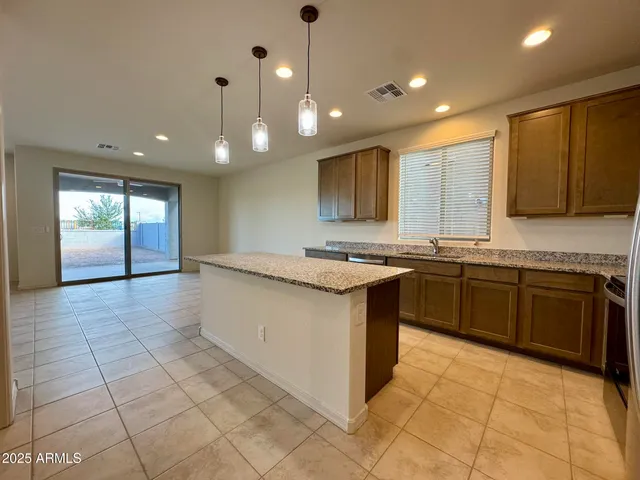 a large kitchen with stainless steel appliances granite countertop a sink and cabinets