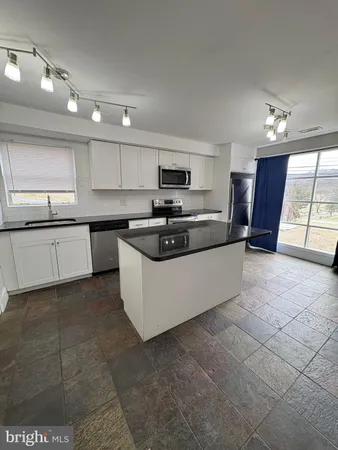 a large kitchen with cabinets a sink and a stove