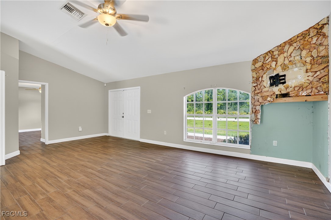 8811 Buckingham Road Fort Myers, FL 33905 - Photo 11 of 30 a view of an empty room with wooden floor and a window