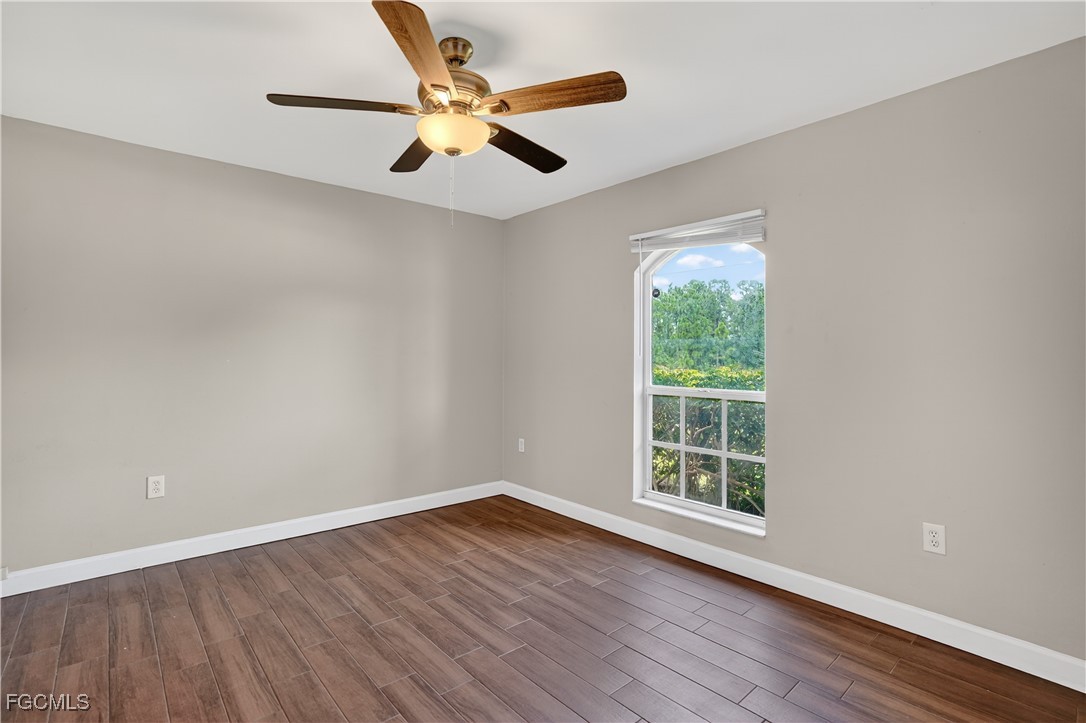 8811 Buckingham Road Fort Myers, FL 33905 - Photo 24 of 30 a view of an empty room with wooden floor and a window