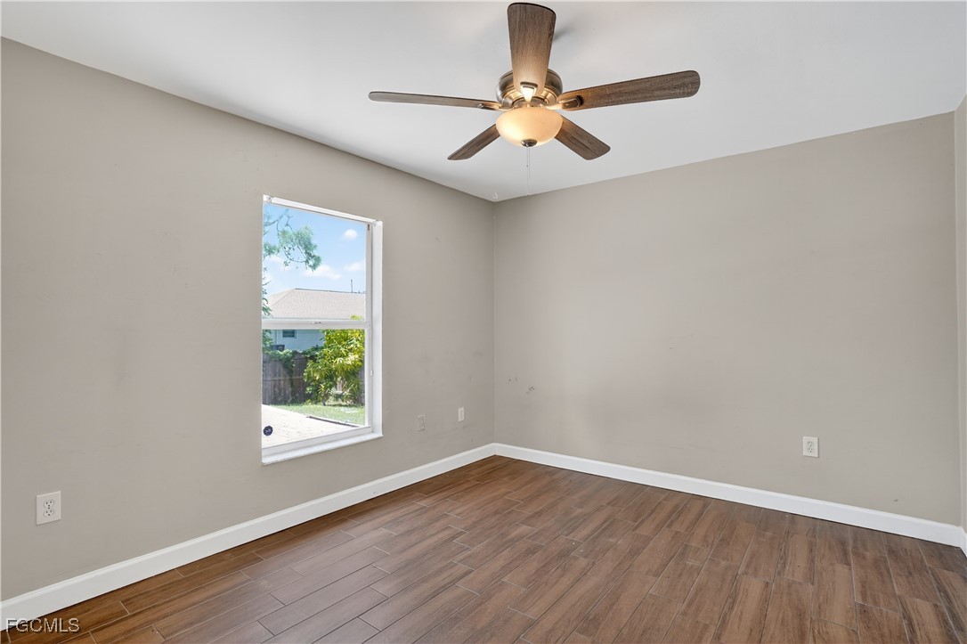 8811 Buckingham Road Fort Myers, FL 33905 - Photo 27 of 30 an empty room with wooden floor fan and windows