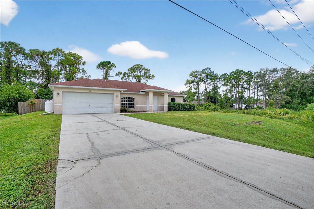 8811 Buckingham Road Fort Myers, FL 33905 - Photo 28 of 30 a front view of a house with a yard and potted plants
