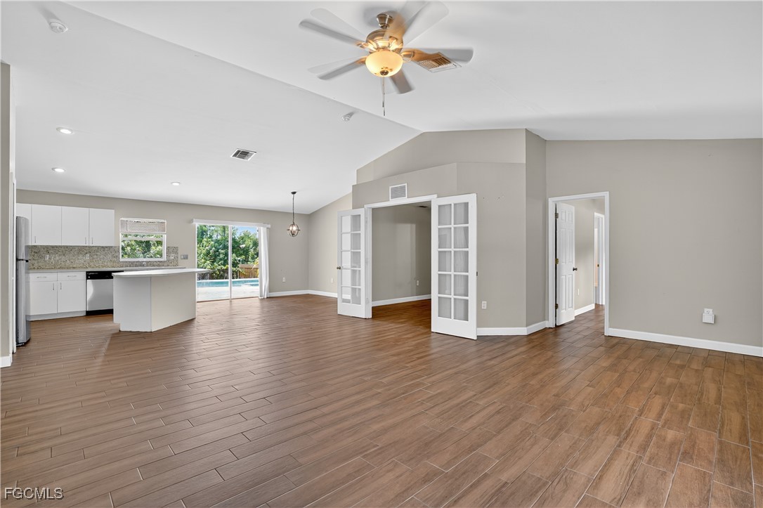 8811 Buckingham Road Fort Myers, FL 33905 - Photo 10 of 30 a view of an empty room with window wooden floor and a kitchen