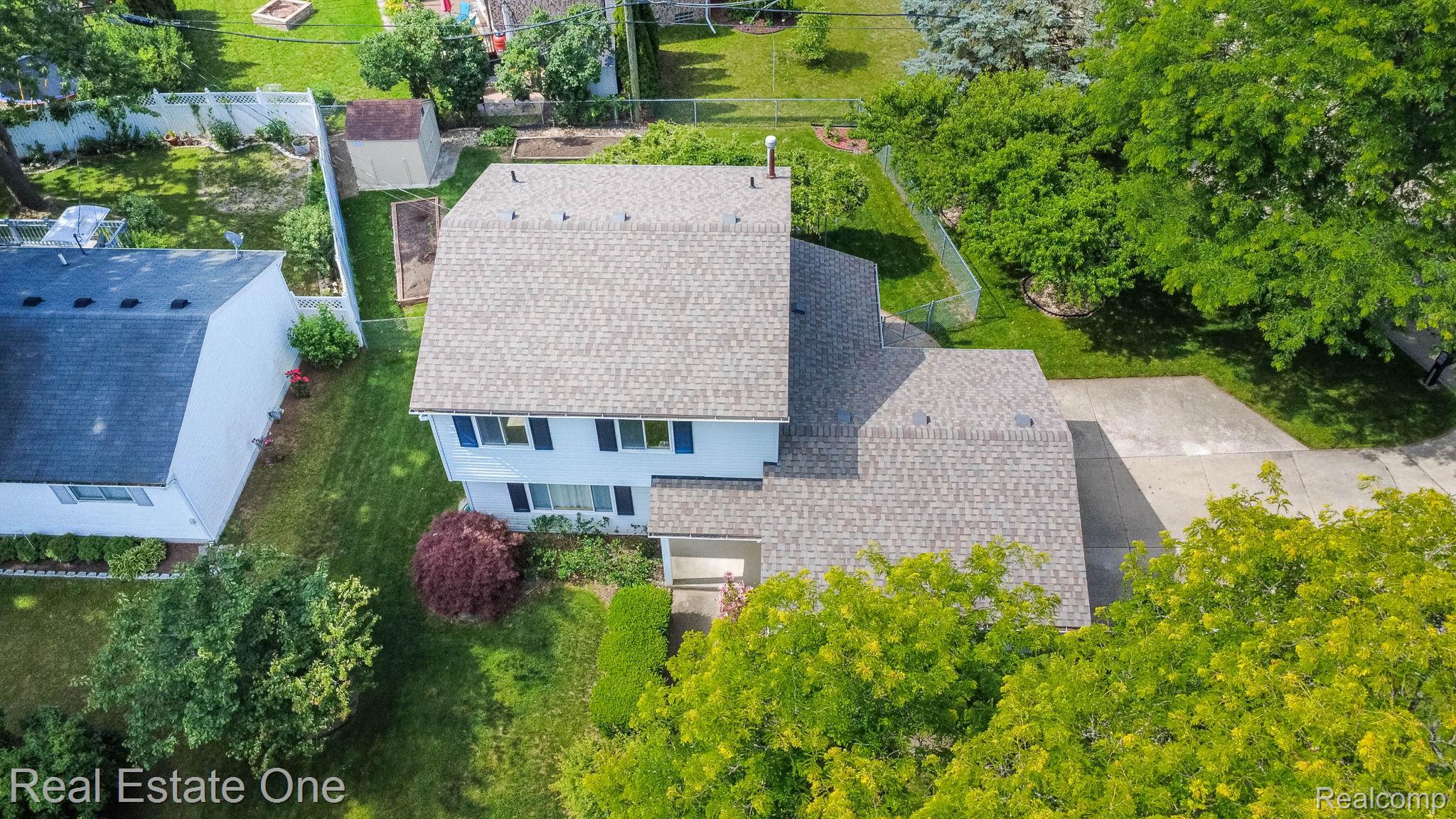13912 Clinton River Road Sterling Heights, MI 48313 - Photo 35 of 43 Two-story residence with a gray shingle roof and blue window shutters