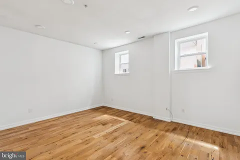a view of empty room with wooden floor