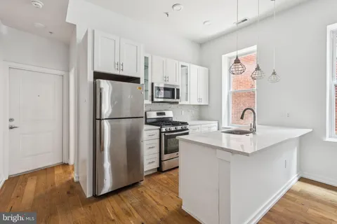 a kitchen with a refrigerator sink and cabinets
