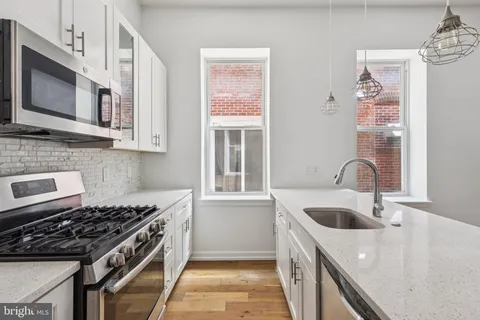a kitchen with stainless steel appliances granite countertop a sink stove and microwave