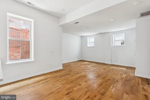 a view of empty room with wooden floor