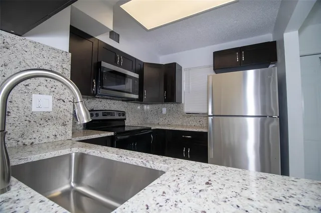 a kitchen with a refrigerator sink and microwave