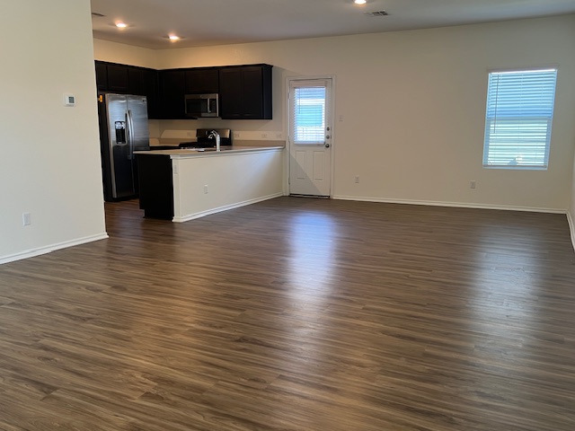 379 Geode Glen Maxwell, TX 78656 - Photo 12 of 12 Kitchen with appliances with stainless steel finishes, light countertops, dark wood finished floors, and open floor plan