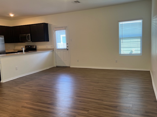 379 Geode Glen Maxwell, TX 78656 - Photo 2 of 12 Kitchen with baseboards, stainless steel microwave, dark wood-type flooring, light countertops, and a sink