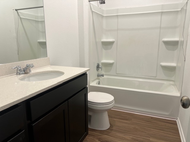 379 Geode Glen Maxwell, TX 78656 - Photo 7 of 12 Bathroom with shower / bathing tub combination, vanity, toilet, and wood finished floors