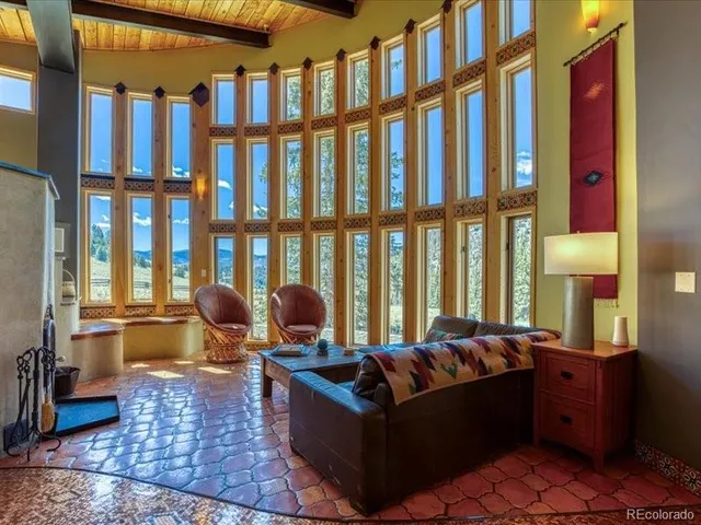 a living room with fireplace furniture and a floor to ceiling window