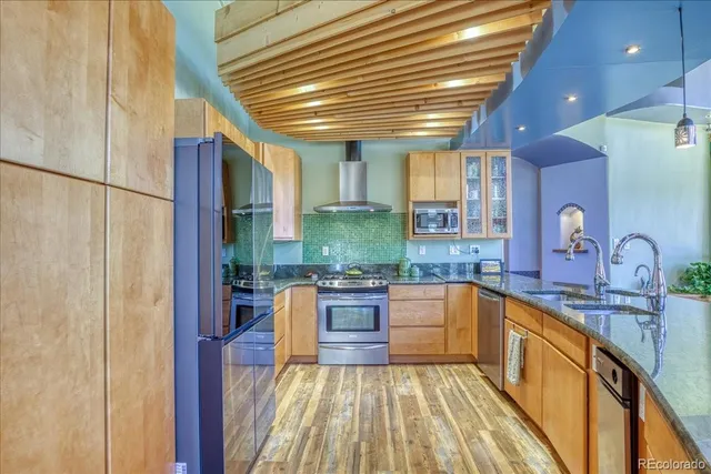 a kitchen with stainless steel appliances granite countertop a stove a sink and a microwave