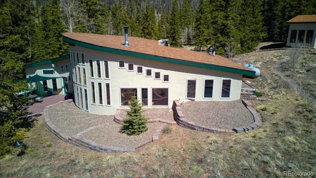 a view of a house with backyard and sitting area