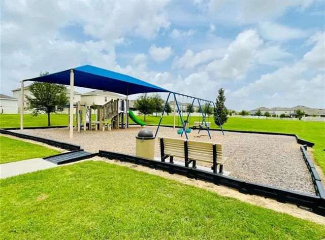 a view of outdoor space with playground and green space