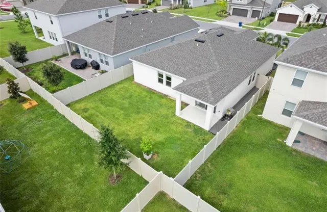 an aerial view of a house with a backyard