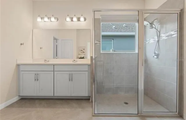 a bathroom with a shower sink and mirror