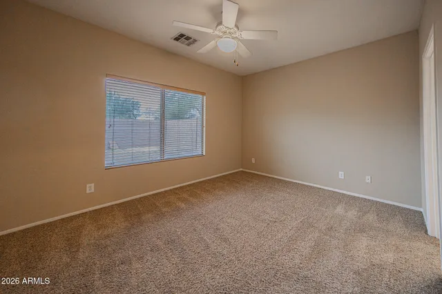 an empty room with a window and a ceiling fan