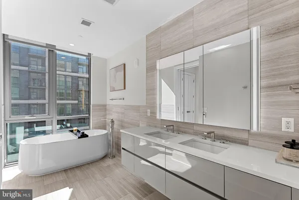 a bedroom with a bed and large windows