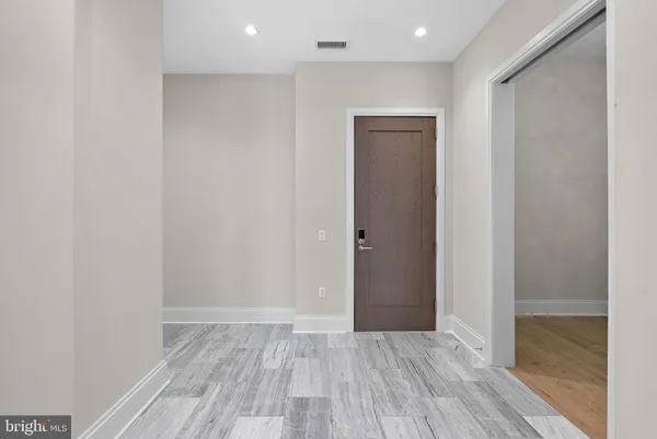 a living room with furniture a rug potted plant and a large window
