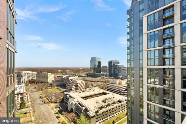 a view of a hallway with wooden floor and windows