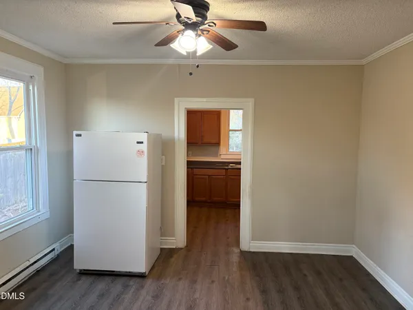 a view of a kitchen with a refrigerator a ceiling fan and wooden floor
