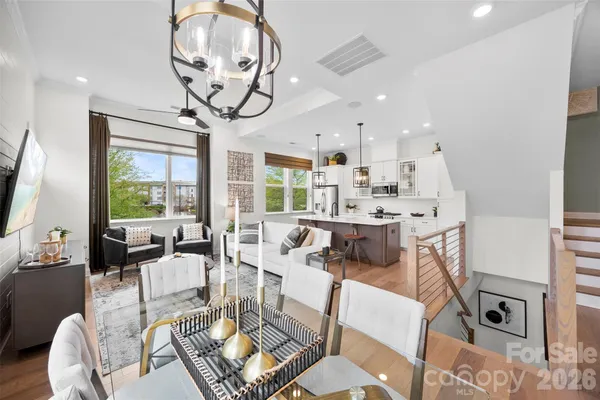a kitchen with stainless steel appliances a refrigerator a sink a stove a table and chairs