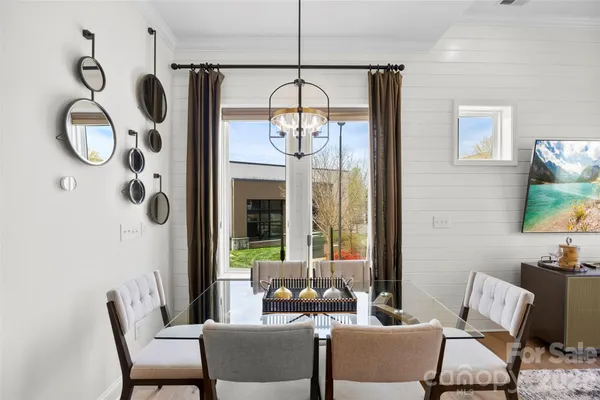 a kitchen with stainless steel appliances a dining table chairs and couches with wooden floor