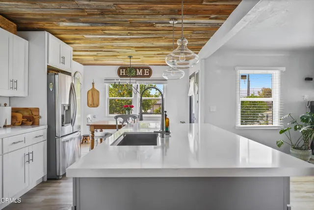 a kitchen with stainless steel appliances a sink a counter space cabinets and furniture