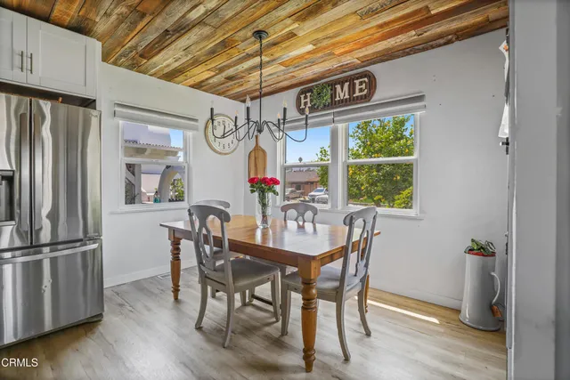 a dining room with furniture a chandelier and wooden floor