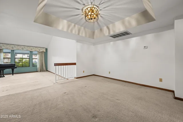 an empty room with windows and fireplace