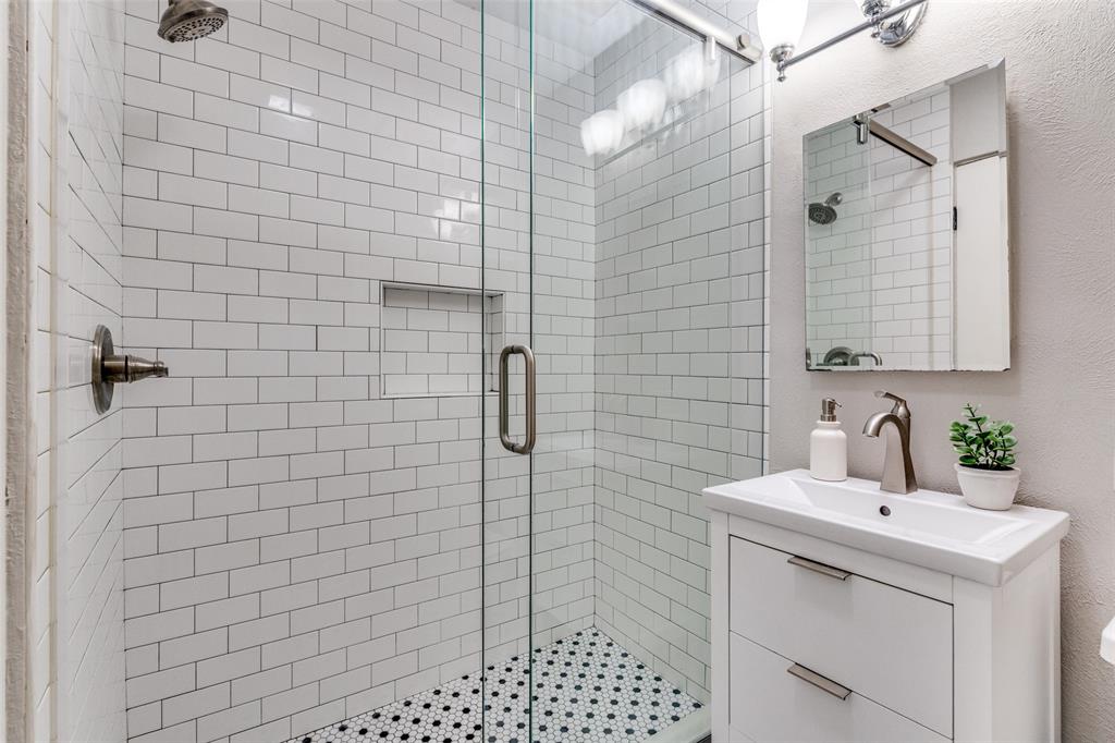 3623 Hawthorne Avenue Dallas, TX 75219 - Photo 21 of 28 Renovated full bath with frameless glass shower, subway tile surround, and contemporary vanity.