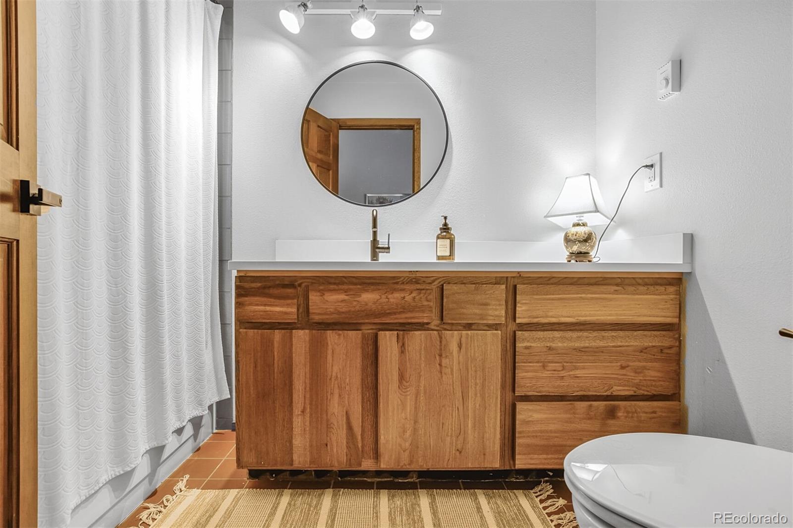 23646 Genesee Village Road Golden, CO 80401 - Photo 13 of 29 a bathroom with a toilet a sink and mirror