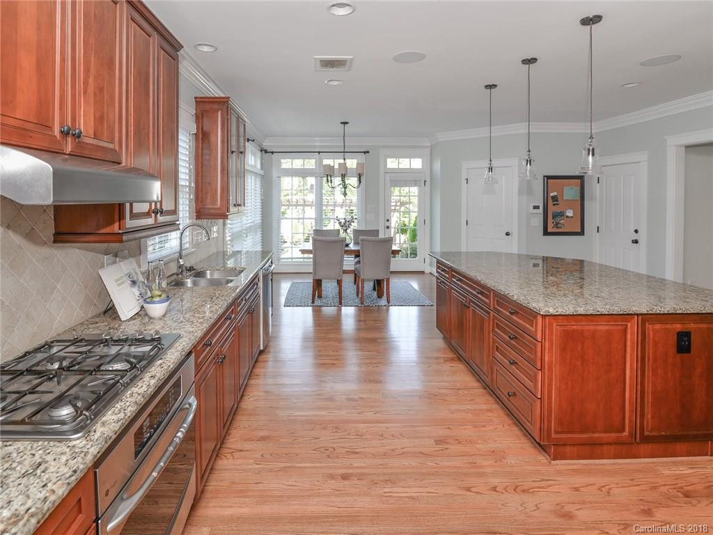4317 Birkshire Heights Fort Mill, SC 29708 - Photo 12 of 23 a large kitchen with stainless steel appliances granite countertop a stove a sink dishwasher and cabinets with wooden floor