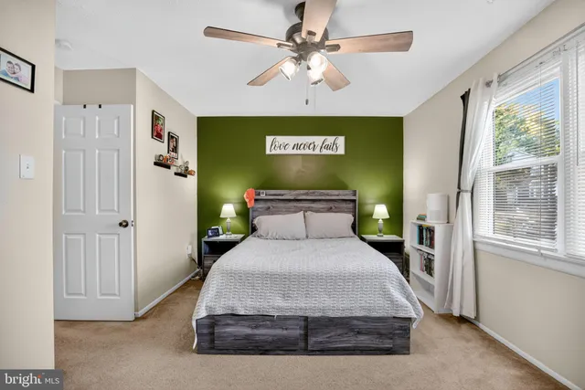 a spacious bedroom with a large bed and a chandelier