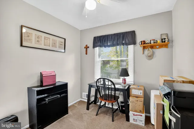 a view of a workspace with furniture and a window