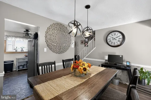 a view of a dining room and livingroom with furniture wooden floor a chandelier