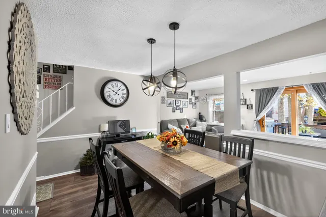 a view of a dining room with furniture a rug and wooden floor