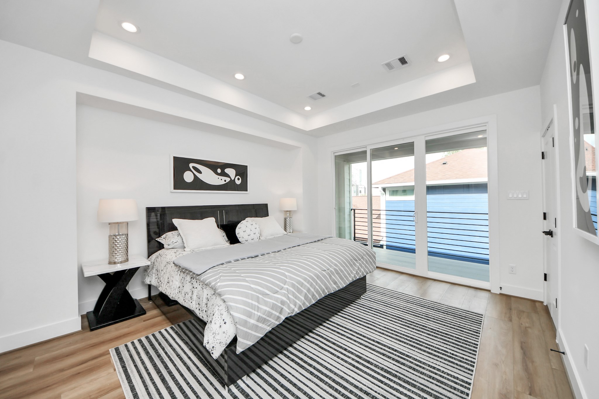 505 Middle Street Houston, TX 77003 - Photo 23 of 46 Experience luxurious comfort in this bright, second-floor primary bedroom, featuring sleek modern design and a private balcony.