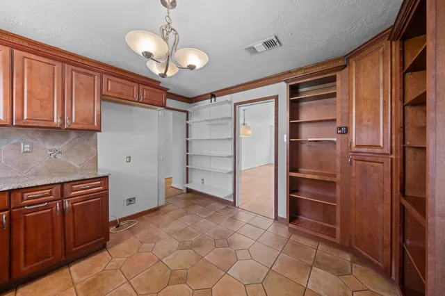 a kitchen with granite countertop a refrigerator and cabinets